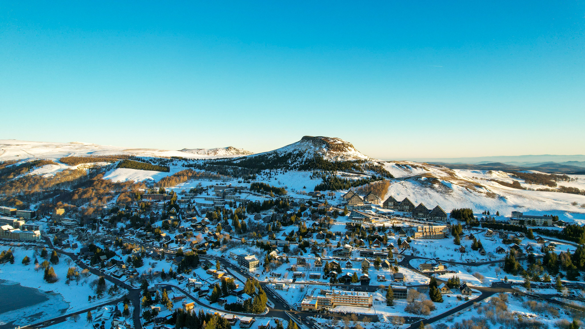 Super Besse seen from the sky, the Puy du Chambourguet under the rays of the sun at sunrise