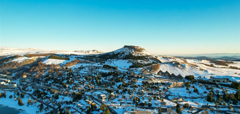Super Besse seen from the sky, the Puy du Chambourguet under the rays of the sun at sunrise