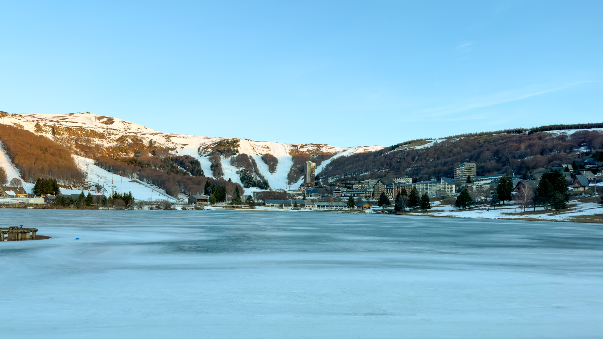 From the Lac des Hermines, panorama of the town center of Super Besse under a winter sun